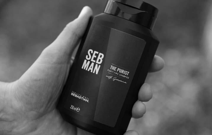 Product bottle of anti-dandruff shampoo in the palm of a man's hand
