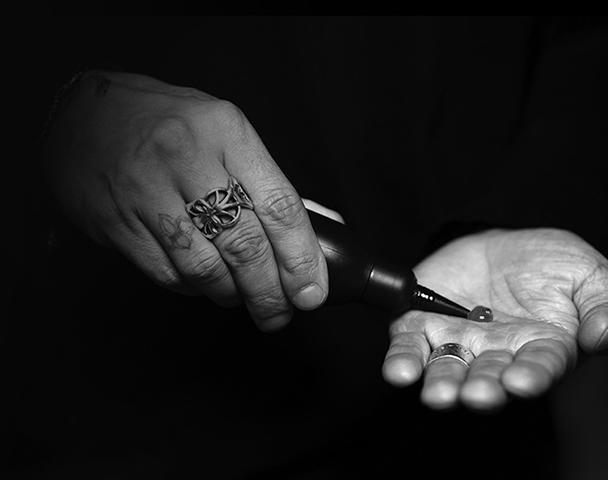 One hand squeezes a tiny amount of liquid wax into the other