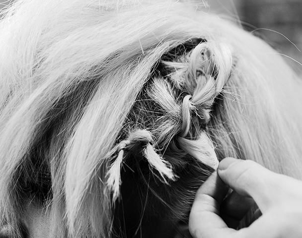 Close-up of a woman's head with a section of her short blonde hair tied in thick knots